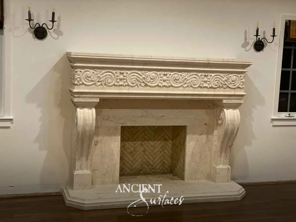 Pale ivory limestone fireplace mantel with a carved scrolling vine frieze, scrolled console jambs and a stepped stone hearth