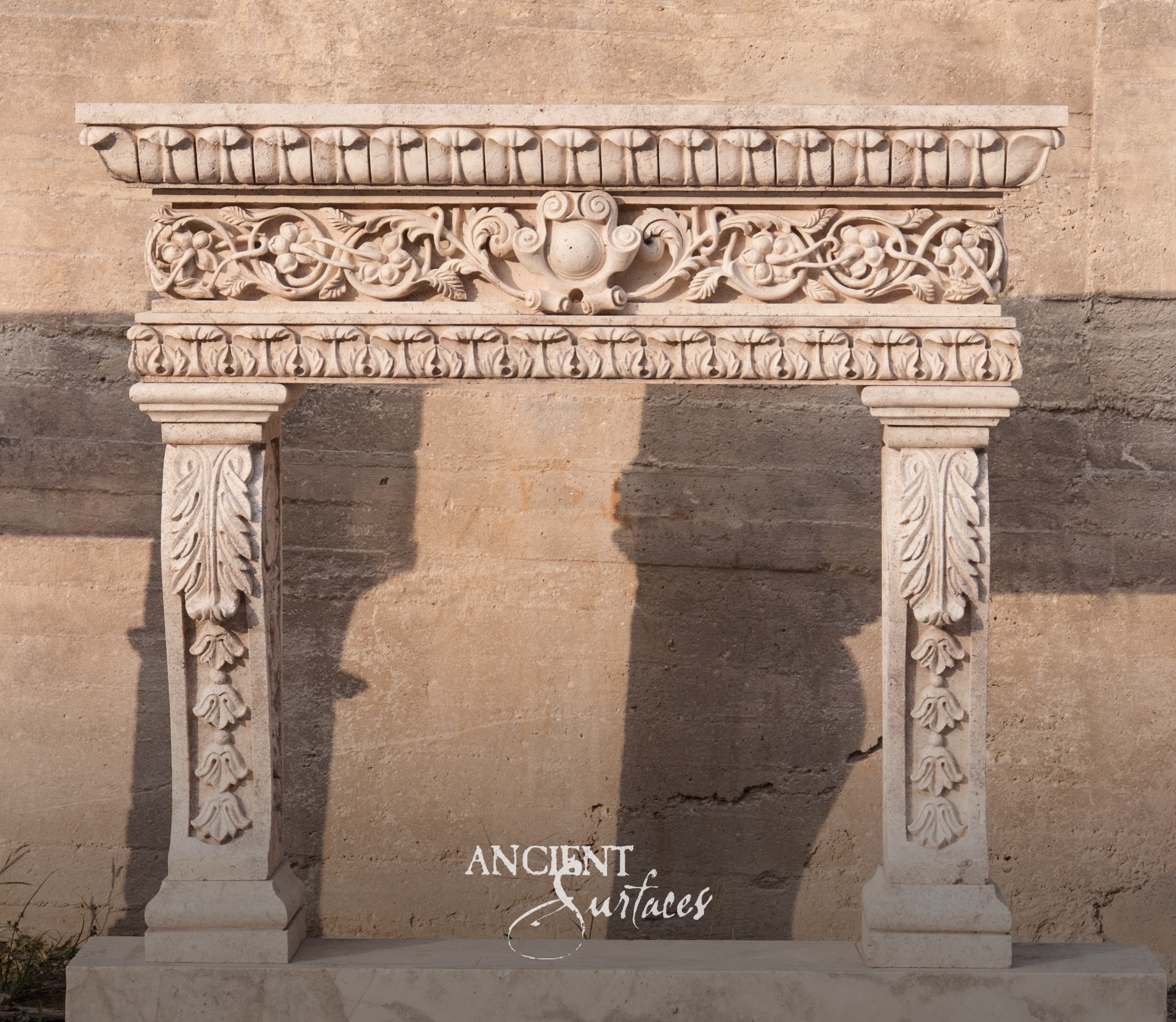 Ancient Surfaces carved reclaimed limestone fireplace mantel with a grapevine frieze, leaf molded cornice and acanthus pilaster jambs