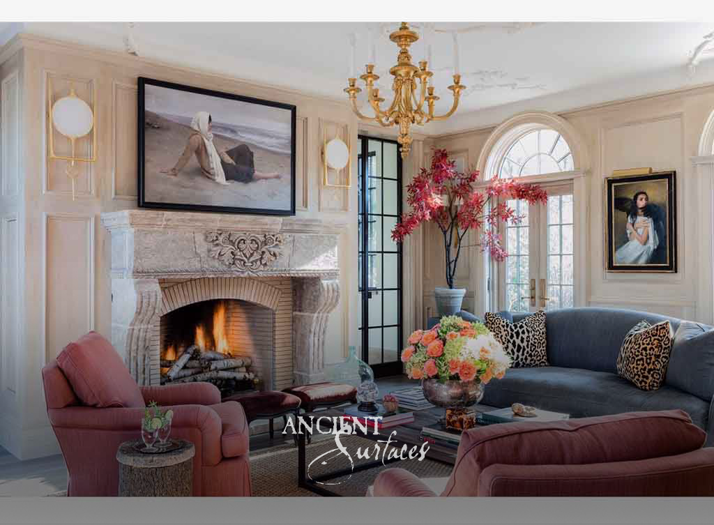 Weathered antique limestone fireplace mantel with a carved foliate cartouche frieze and console jambs around a lit arched brick firebox
